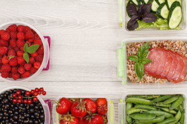 Siyah frenk üzümü, çilek, ahududu, yeşil bezelye, kaynamış karabuğday lapası ve bir dilim et, taze salatalık ve gri arka planda fotokopi alanı olan salata.