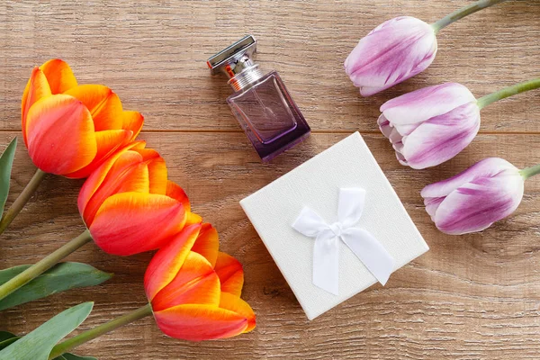 Pudełko Prezentami Butelka Perfum Czerwonymi Liliowymi Tulipanami Drewnianych Deskach Koncepcja — Zdjęcie stockowe