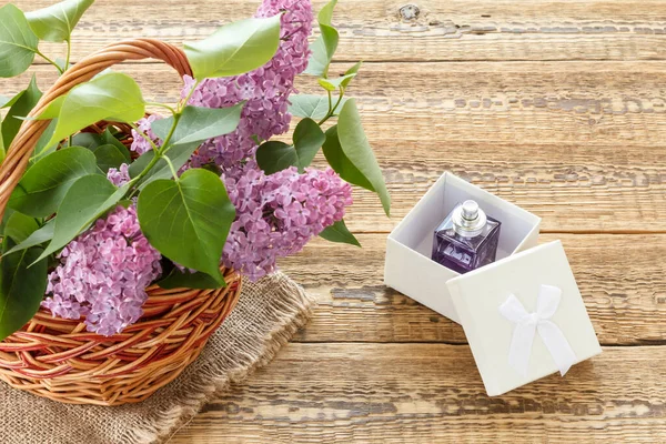 Wiklinowy Kosz Liliowymi Kwiatami Białe Pudełko Butelką Perfum Drewnianych Deskach — Zdjęcie stockowe