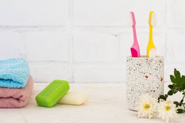 Beyaz arka planda diş fırçası, havlu ve sabunla dolu bir kutu. Aksesuarları yıka.