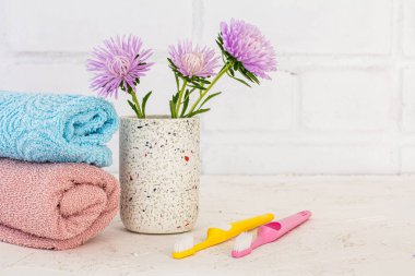 Havlular, diş fırçaları ve beyaz arka planda astar olan bir kutu. Kadın kozmetik ürünleri ve aksesuarları.