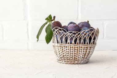 Beyaz arka planda hasır bir sepette olgun erikler topladım. Sadece meyve topladım..