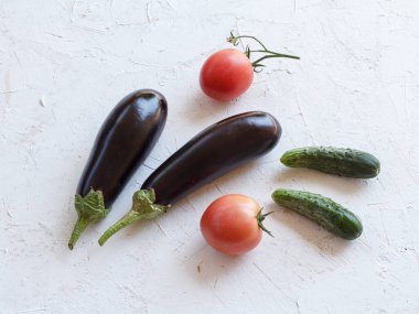 Sadece beyaz yapılı arka planda domates, salatalık ve patlıcan topladım. Sadece sebze topladım. Üst görünüm.