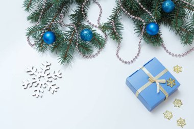 Noel süsü. Hediye kutusu, beyaz arka planda topları olan köknar ağacı dalları. Üst Manzara. Noel tebrik kartı konsepti.