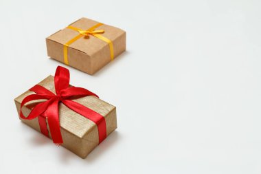 Beyaz arka planda kırmızı ve sarı kurdeleli hediye kutuları. Tebrik kartı konsepti. Kopyalama alanı olan üst görünüm.