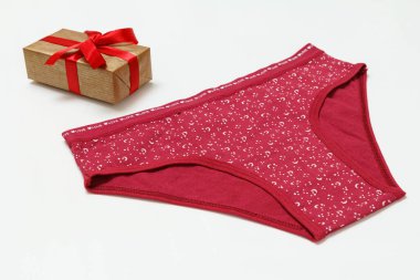 Mavi pamuklu külot ve beyaz arka planda hediye kutusu. Kadın iç çamaşırı seti. Üst görünüm.