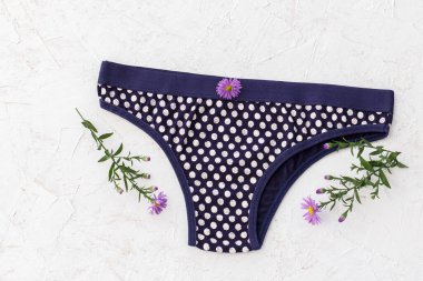 Beyaz arka planda çiçekli siyah pamuklu külot. Kadın iç çamaşırı seti. Üst görünüm.