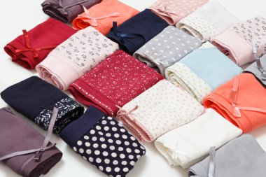 Beyaz arka planda farklı renkte katlanmış pamuk külotlar. Kadın iç çamaşırı seti. Üst görünüm.