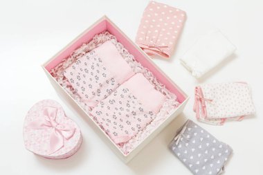 Bir kutuda ve beyaz arka planda farklı renklerde katlanmış pamuk külotlar. Kadın iç çamaşırı seti. Üst görünüm.