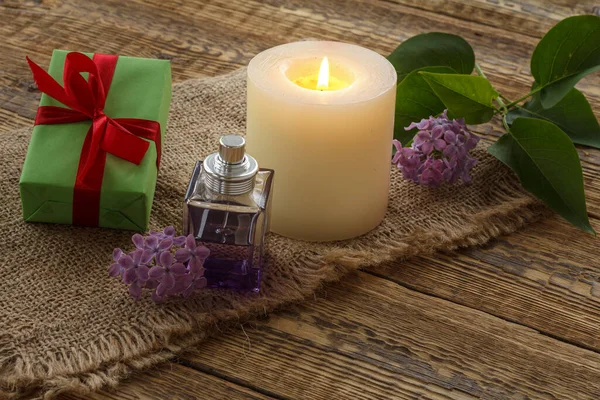 Vela Ardente Uma Garrafa Perfume Uma Caixa Presente Flores Lilás — Fotografia de Stock