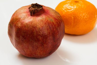 Beyaz arka planda nar ve mandalina. Organik meyveler.