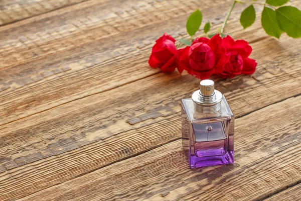 赤いバラで飾られた木製の板に香水のボトル トップ表示 — ストック写真