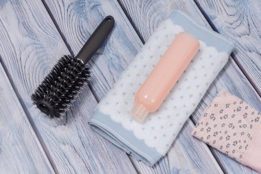 Bir şişe şampuan, havlu, tarak ve ahşap arka planda katlanmış pamuk külot. Kadın kozmetik ve aksesuarları. Üst görünüm.