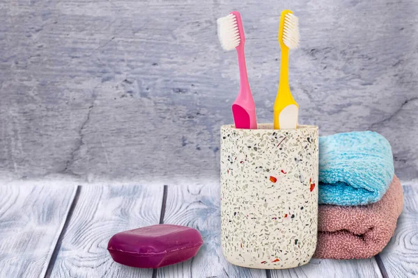 Can with toothbrushes, towels and soap on wooden background. Wash accessories.