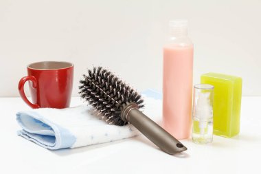 Bir şişe şampuan, havlu, tarak ve sabun beyaz arka planda. Kadın kozmetik ürünleri ve aksesuarları bir fincan kahveyle.
