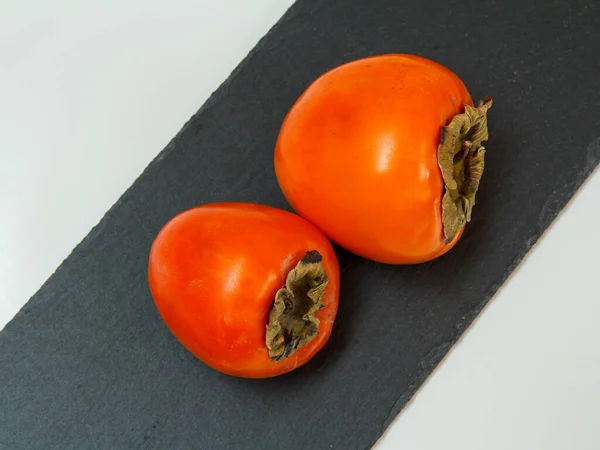 Delicious Ripe Persimmon Fruits Black Stone Cutting Board Organic Fruits — Stock Photo, Image