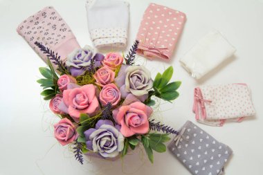 Yapay çiçekler ve arka planda farklı renklerde katlanmış pamuk külotlar. Üst görünüm.