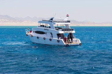 SHARM EL SHEIKH, EGYPT - 7 Haziran 2021: Sharm El Sheikh, Mısır 'da Kızıldeniz koyunda turistlerle dolu lüks bir yat. Turistler zengin sualtı dünyasıyla mercan resiflerini görmek için şnorkelle yüzüyorlar.