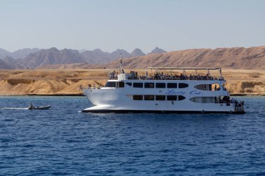 SHARM EL SHEIKH, EGYPT - 7 Haziran 2021: Sharm El Sheikh, Mısır 'da Kızıldeniz koyunda turistlerle dolu lüks bir yat. Mercan kayalıklarını görmek için şnorkelle yüzüyor.