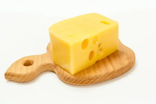 一片奶酪放在白色背景的木制切菜板上 — 图库照片