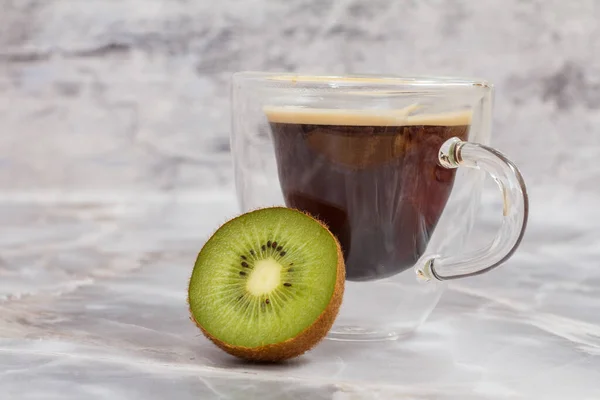 Cup of coffee and kiwi on kitchen desk. — Stock Photo, Image