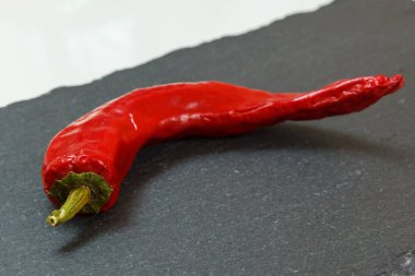 Taş kesme tahtasının üzerinde kırmızı biber.