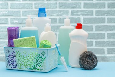 Sepette bulaşık deterjanı, süngerler ve tuğla duvarda fırça..