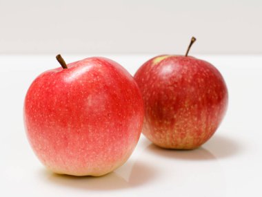 Beyaz arka planda yakın plan kırmızı elmalar. Sığ alan derinliği.