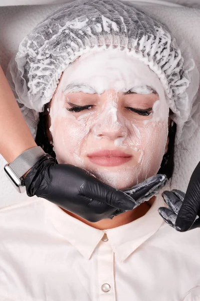 Kozmetik Uzmanlarının Elleri Siyah Steril Eldivenlerle Hastaların Yüzüne Temizleyici Köpük — Stok fotoğraf