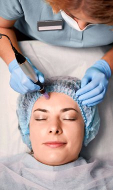 Kadın müşteri gözlerini kapatıp gülümserken, cilt bakımı sırasında cilt bakımı yaparken steril eldivenli güzellik uzmanlarının ellerini kapatın. Güzellik kavramı, cilt bakımı ve kolajen indüksiyon terapisi.