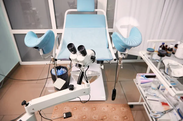 Interiors of gynecological cabinet with optical instrument for colposcopy. Empty gynecology office with modern colposcope and medical tools. Concept of gynecology, obstetrics and medical equipment.