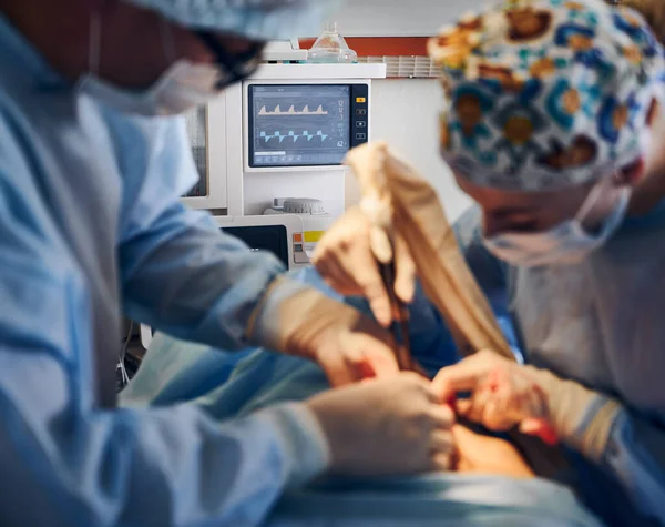 手術室でのおなかタック手術を行う心拍数モニターと医療チームに焦点を当てます 患者の腹部に外科手術を行う整形外科医とアシスタント 医療機器の概念 — ストック写真