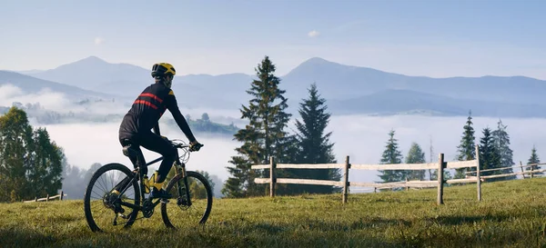 Uomo Bicicletta Sulla Collina Erbosa Guardando Belle Montagne Nebbiose Bicicletta — Foto Stock
