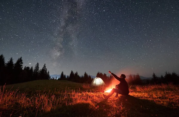 인간은 모닥불 언덕에 하늘을 별들과 산골짜기 아래있는 은하수를 여행자 모닥불 — 스톡 사진