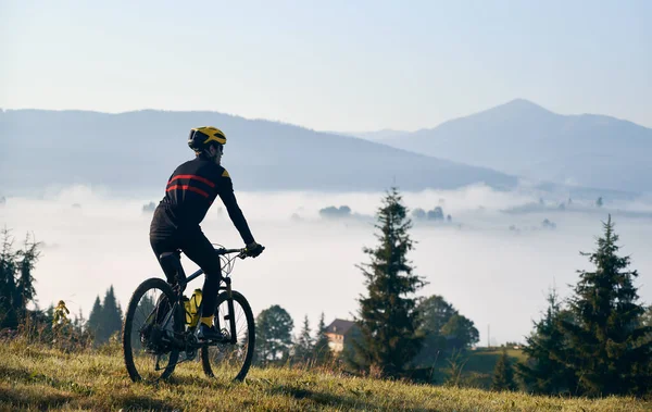 Egy Férfi Kerékpáros Sziluettje Biciklizős Öltönyben Biciklivel Füves Dombon Férfi — Stock Fotó