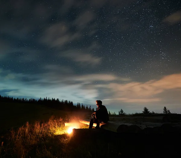 Ein Junger Mann Sitzt Auf Baumstämmen Lagerfeuer Den Bergen Unter — Stockfoto