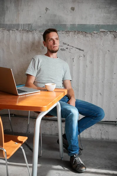 Erkek Dizüstü Bilgisayarı Bir Fincan Kahveyle Masada Oturuyor Genç Adam — Stok fotoğraf