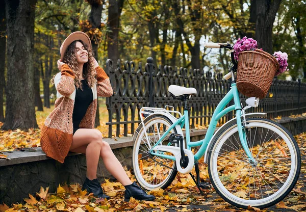 Kentteki Sonbahar Parkında Modern Mavi Bisikletin Yanında Oturan Bej Şapkalı — Stok fotoğraf