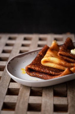 Ahşap arka planda bal ve tereyağlı krepler, yakın çekim manzarası