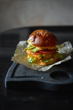 Hamburger, tahta bir tahtanın üzerindeki kağıt parçasında servis edilir. Portre yönelimi