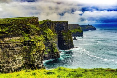 Moher Claire County İrlanda 'sının renkli yeşil çim kayalıkları. Uçurumlar Atlantik Okyanusu 'nun 270 metre yukarısına yükseliyor ve İrlanda kıyısı boyunca 9 mil boyunca koşuyor. Unesco sitesi İrlanda 'da en çok ziyaret edilen yerlerden biri ve birçok film sitesi. Kayalıklarda deniz kuşu yuvaları var.