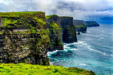 Moher Claire County İrlanda 'sının renkli yeşil çim kayalıkları. Uçurumlar Atlantik Okyanusu 'nun 270 metre yukarısına yükseliyor ve İrlanda kıyısı boyunca 9 mil boyunca koşuyor. Unesco sitesi İrlanda 'da en çok ziyaret edilen yerlerden biri ve birçok film sitesi. Kayalıklarda deniz kuşu yuvaları var.