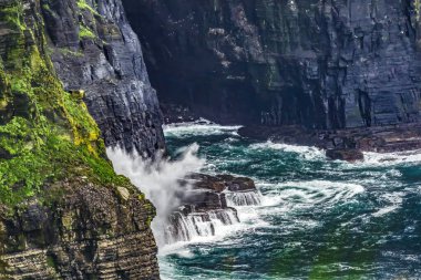 Moher Claire County İrlanda 'sının renkli Cove Waves Seabirds uçurumları. Uçurumlar Atlantik Okyanusu 'nun 270 metre yukarısına yükseliyor ve İrlanda kıyısı boyunca 9 mil boyunca koşuyor. Unesco sitesi İrlanda 'da en çok ziyaret edilen yerlerden biri ve birçok film sitesi. 