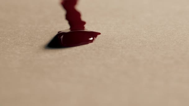 Красные капли крови стекают по белой бумаге, макро выстрел — стоковое видео
