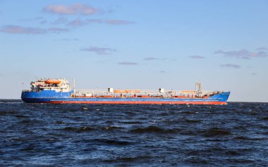 Bir sanayi tüccarı fırtınadan önce küçük dalgalar üzerinde yelken açar. Kargoyu taşıyan gemi malların teslimat noktasına gidiyor..