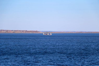 Bir sanayi tüccarı fırtınadan önce küçük dalgalar üzerinde yelken açar. Kargoyu taşıyan gemi malların teslimat noktasına gidiyor..
