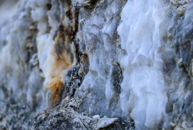 Farklı renkte kuvars kayaları. Gri, beyaz, turuncu kuvars depozitoları. Çeşitli taş birikintilerinde ve farklı kaya katmanlarında işlenmemiş yarı değerli taş çeşitliliği..