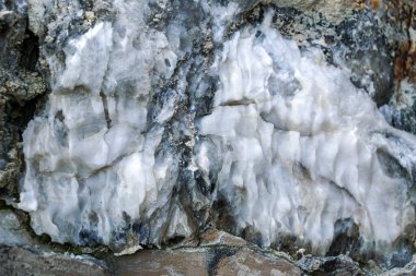 Farklı renkte kuvars kayaları. Gri, beyaz, turuncu kuvars depozitoları. Çeşitli taş birikintilerinde ve farklı kaya katmanlarında işlenmemiş yarı değerli taş çeşitliliği..