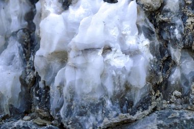 Farklı renkte kuvars kayaları. Gri, beyaz, turuncu kuvars depozitoları. Çeşitli taş birikintilerinde ve farklı kaya katmanlarında kalipdonik çeşitlilikte işlenmemiş yarı değerli taşlar..