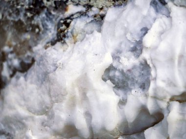 Farklı renkte kuvars kayaları. Gri, beyaz, turuncu kuvars depozitoları. Çeşitli taş birikintilerinde ve farklı kaya katmanlarında kalipdonik çeşitlilikte işlenmemiş yarı değerli taşlar..